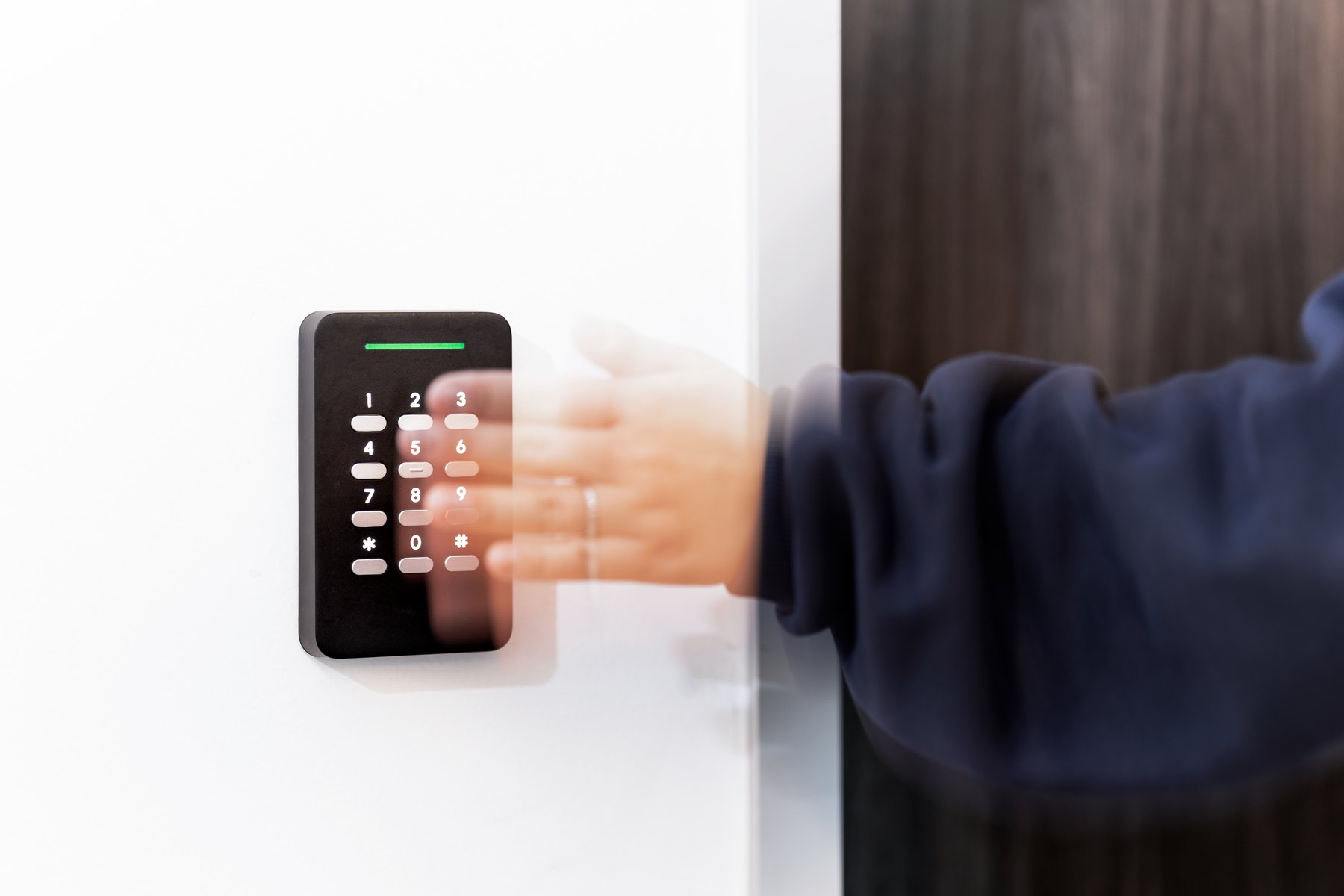 A hand at a Verkada AD64 keypad reader