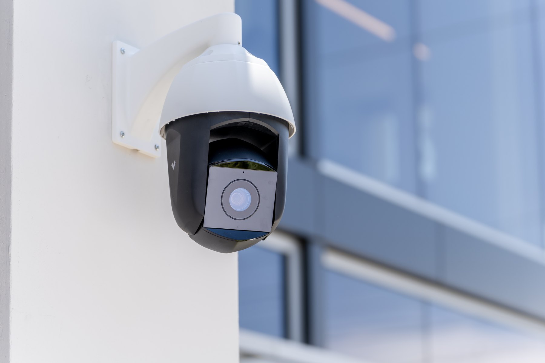 A Verkada PTZ camera on the corner of a glazed building